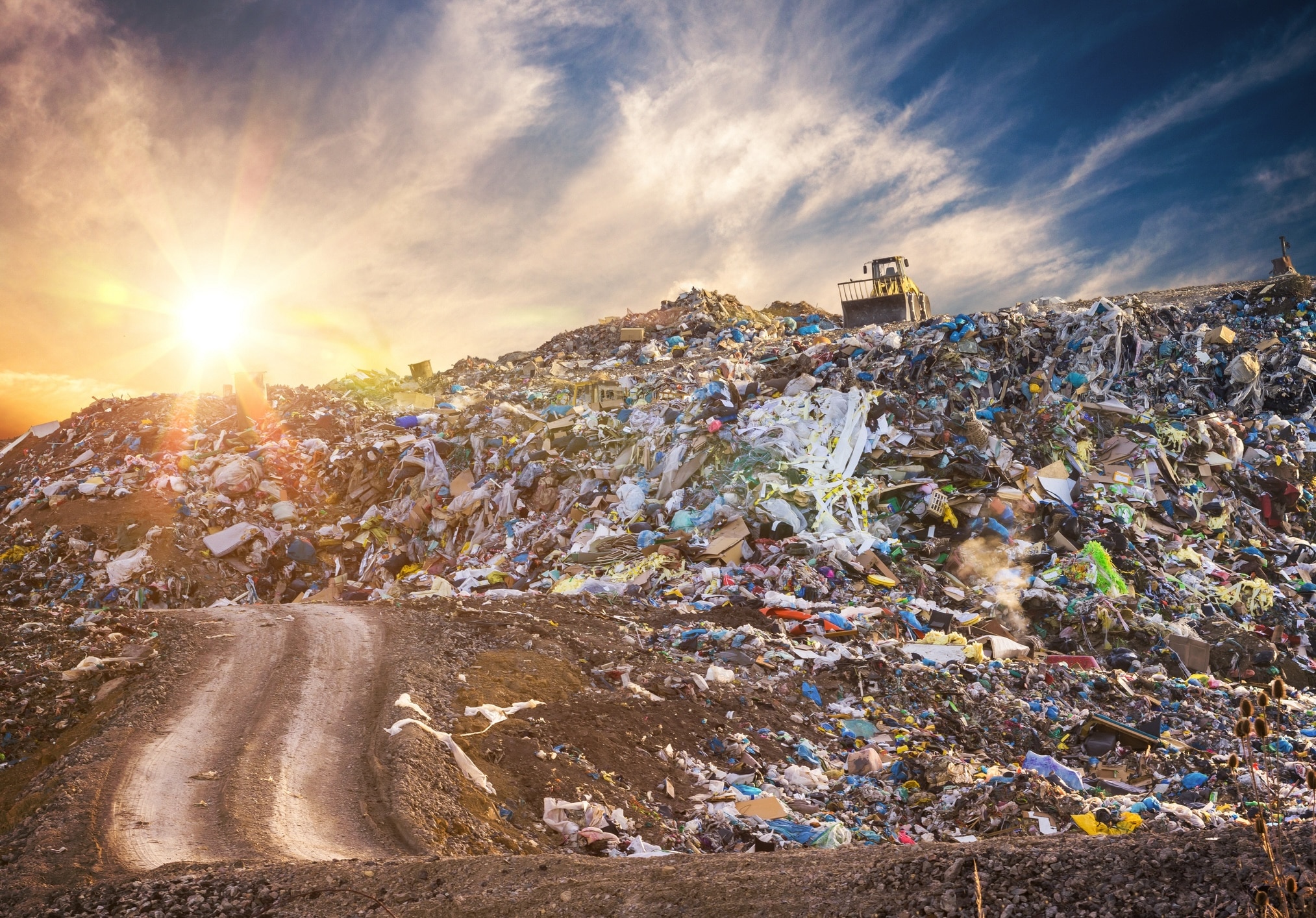 Pollution concept. Garbage pile in trash dump or landfill at sunset.